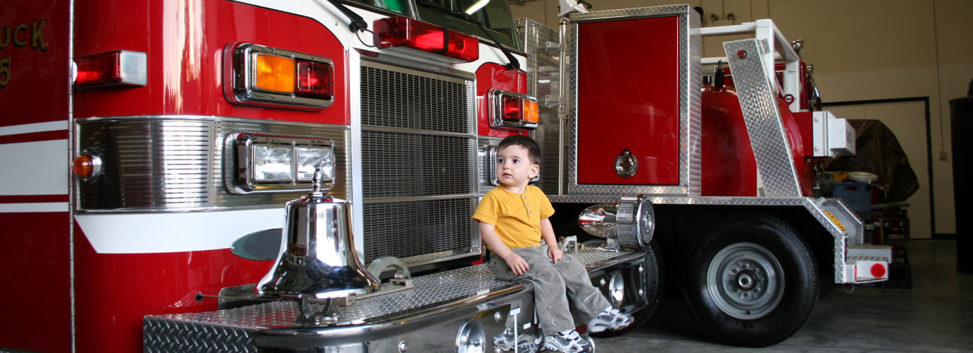 child sitting on fire truck