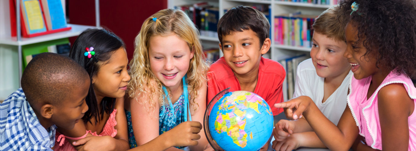 smiling children with globe on table in library